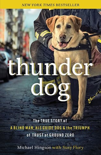 图片是《雷霆犬:一位盲人、他的导盲犬以及在世贸中心遗址上信任的胜利》的书封。画面中一只黄色的拉布拉多犬戴着导盲鞍,站在一位穿着消防员制服的人旁边,背景是城市街道。书名“thunder dog”以大号字体居中,下方小字写着“THE TRUE STORY OF A BLIND MAN, HIS GUIDE DOG & THE TRIUMPH OF TRUST AT GROUND ZERO”,作者为Michael Hingson with Susy Flory。该书封与文档中介绍的书籍信息相契合,直观呈现了书名及作者等关键信息。